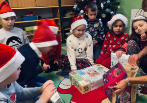 Dzieci otwierają prezenty.