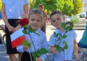 dzieci z flagami i kwiatami