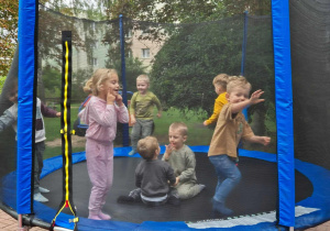 Sześcioro dzieci skaczących na trampolinie.