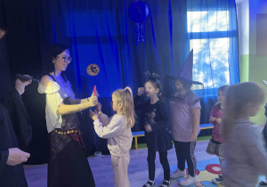 Cyganka trzyma serce a dziewczynka wbija w nie szpilkę.