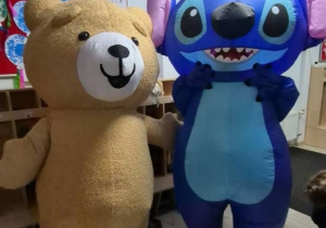 Duże stojące dmuchane postacie z bajek. Po prawej stronie Stich oraz po lewej stronie pluszowy miś.