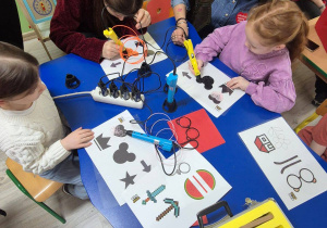 Dzieci tworzące prace plastyczne za pomocą długopisu 3D.