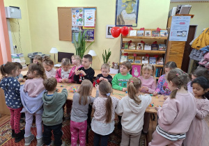 Dzieci wykonujące bransoletki. Nadziewają koraliki na nitki