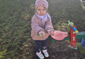 Dziewczynka trzymająca czekoladowe jajka w dłoniach.