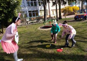 Dzieci szukające czekoladowych jajek w ogrodzie przedszkolnym.