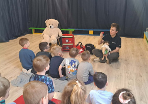 Pani pokazująca małe serce, opatrująca misia.