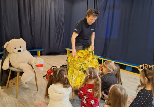 Pani pokazująca koc termiczny złota folia.