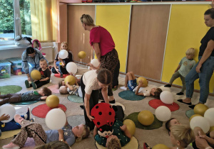 Dzieci leża na dywanie z balonami