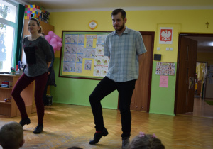 Tancerz i tancerka stepują przed dziećmi