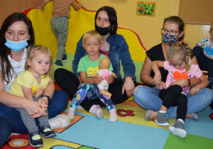 Rodzice trzymają dzieci na kolanach