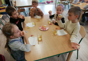 Dzieci zjadają słodki poczęstunek