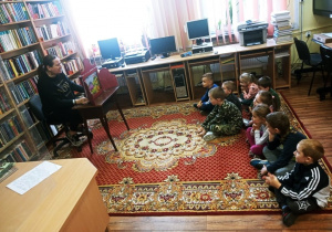 Dzieci słuchają opowiadania pani bibliotekarki.