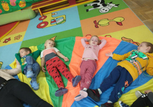 Dzieci leżą na chuście animacyjnej.
