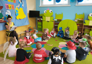 Dzieci słuchają opowiadania nauczycielki.