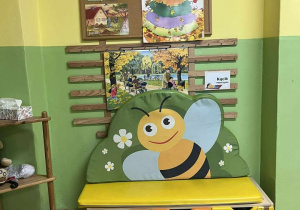 Sala grupy Pszczółki, kolorowy dywan, półki z zabawkami, materac z wizerunkiem Pszczoły