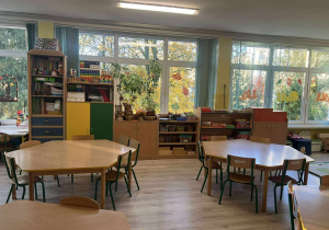 Na pierwszym planie stoliki z krzesełkami w tle widać szafki z zabawkami