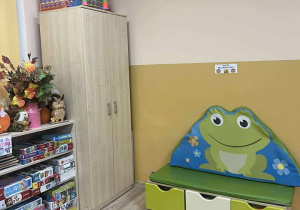 sala grupy "Żabki", kolorowy dywan ze zwierzątkami, na drugim planie szafa, półki z zabawkami oraz materac z wizerunkiem Żabki